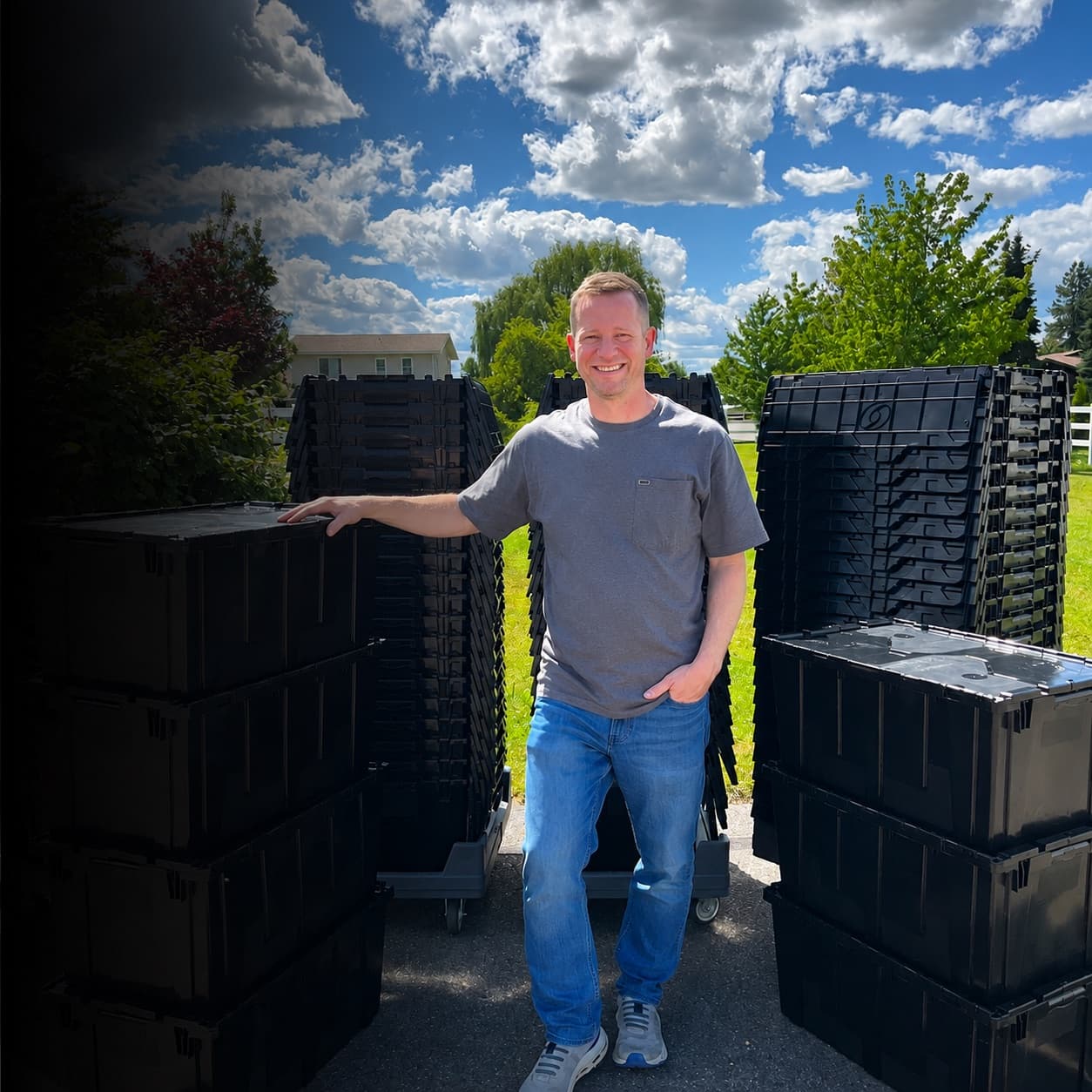 Josh Cypher standing with stacks of Tote Movers rental totes on a Coeur d'Alene driveway