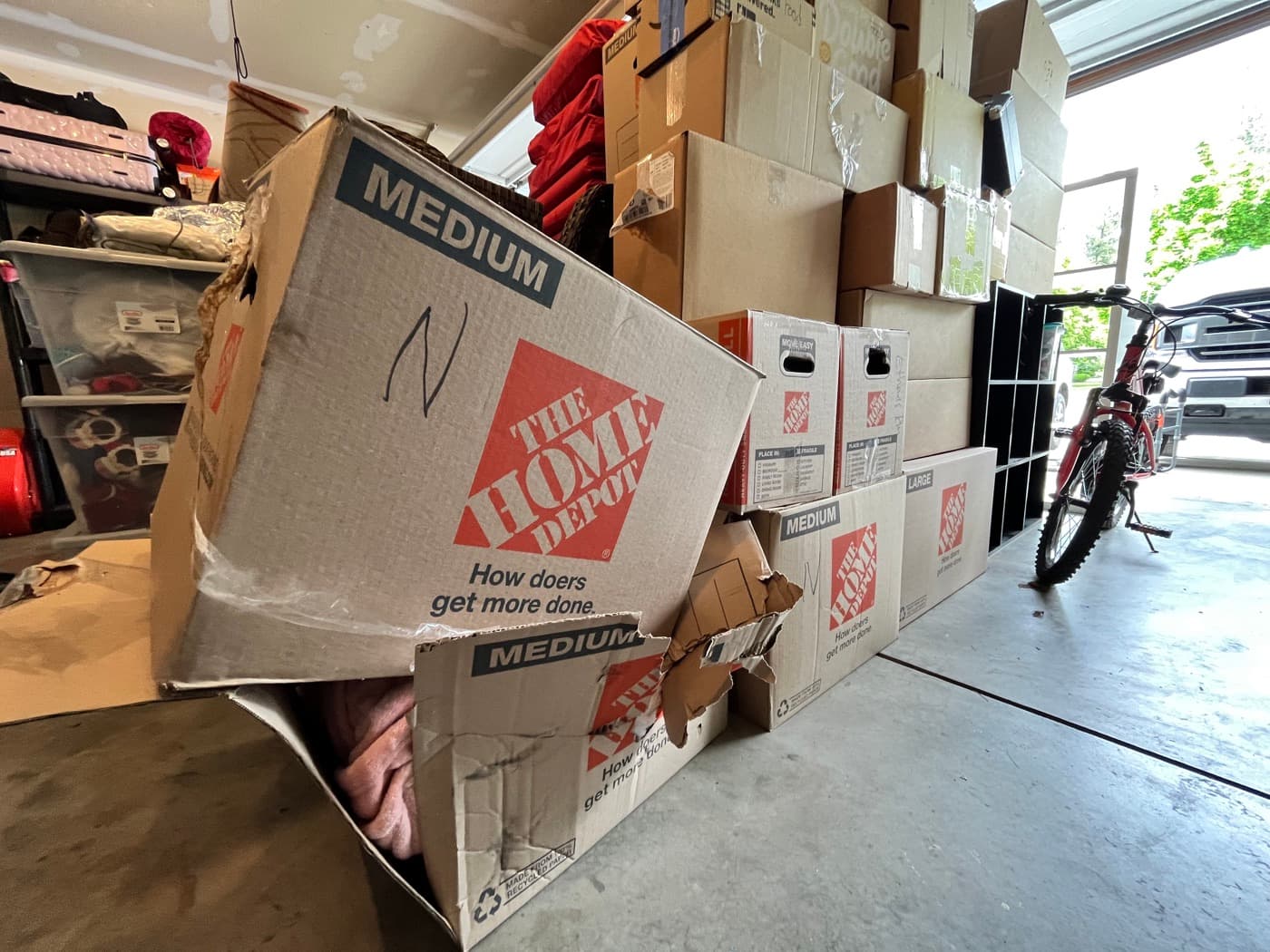 A cardboard moving box crushed and collapsed — exactly the failure mode plastic totes are built to prevent