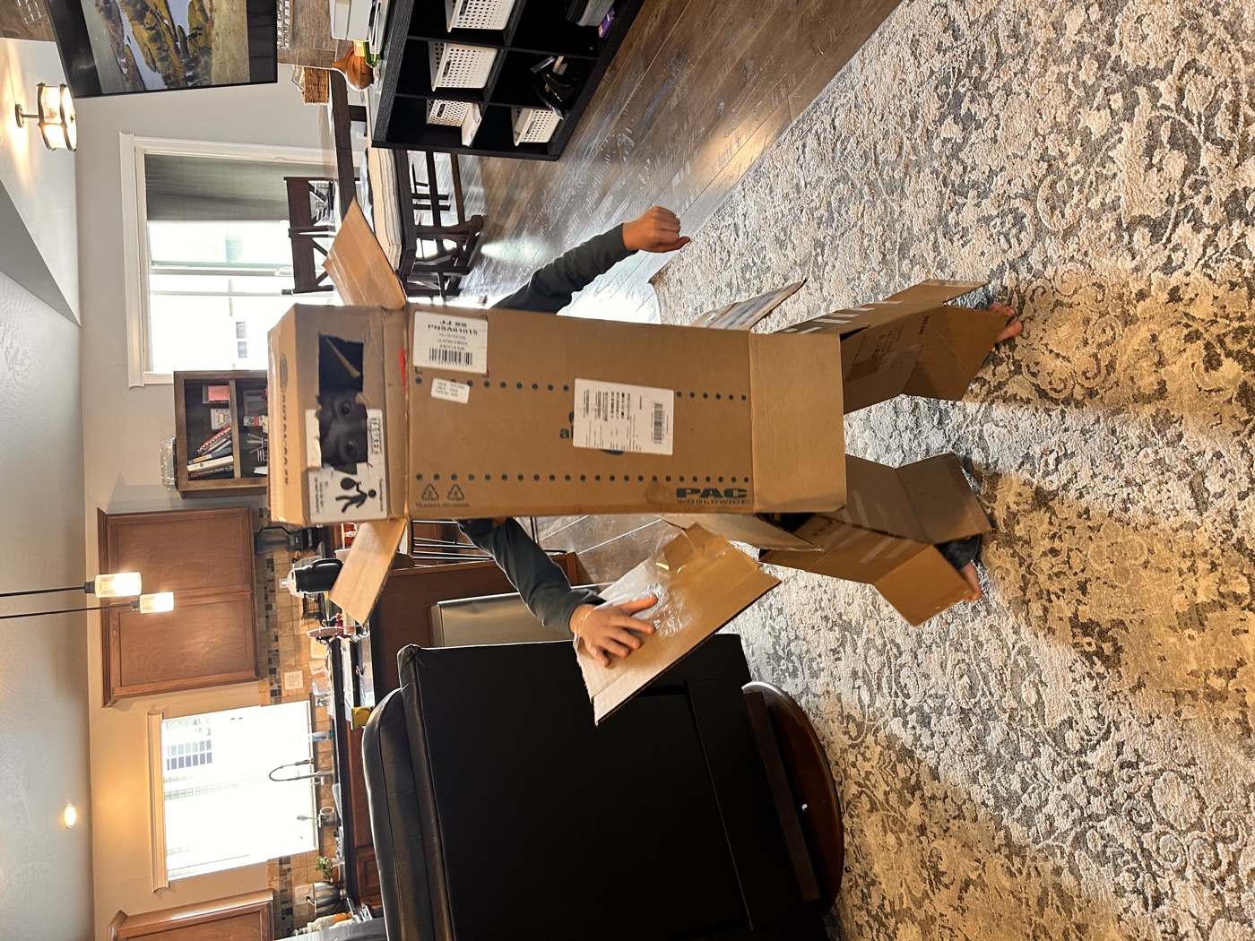 A stack of cardboard moving boxes piled up in a garage from a previous move